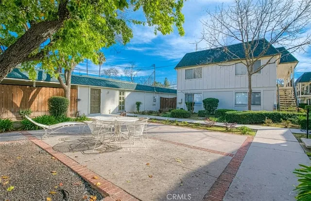 a view of a house with a yard and table and chair under an umbrella