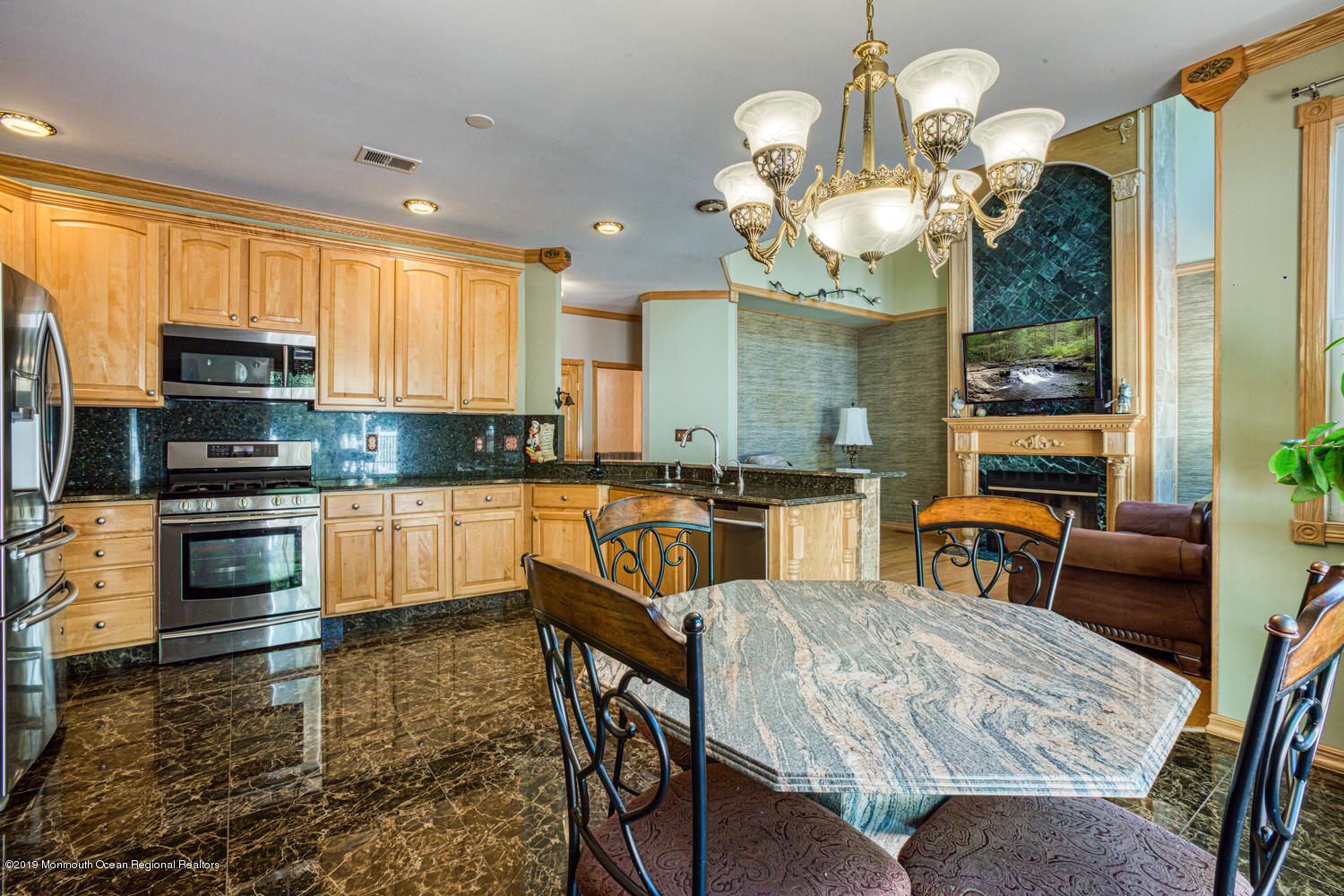 327 Wedgewood Road Morganville, NJ 07751 - Photo 6 of 33 a kitchen with stainless steel appliances granite countertop a stove top oven a sink a dining table and chairs with wooden floor