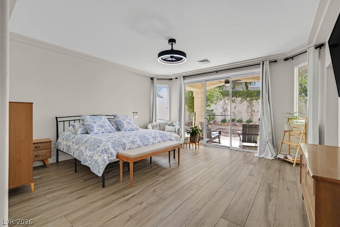 1259 Moon Vision Street Henderson, NV 89052 - Photo 14 of 53 Retreat to a comfortable bedroom featuring durable wood-look tile flooring and direct patio access.