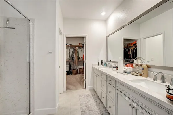 a spacious en suite bathroom with a double vanity sink and mirror