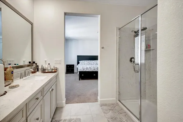 a en suite bathroom with a double vanity sink a mirror and shower