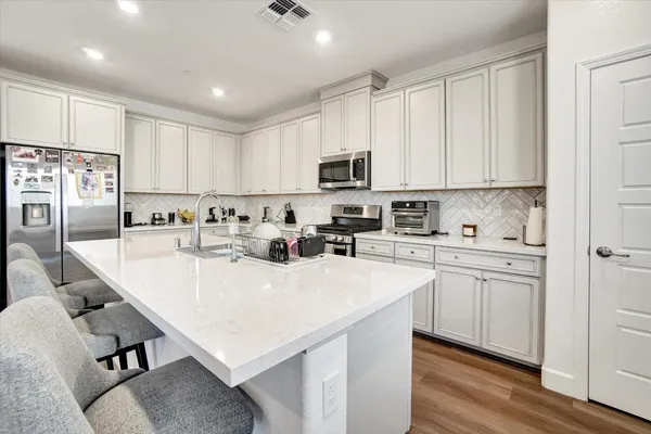 a kitchen with kitchen island a white counter top space cabinets and stainless steel appliances