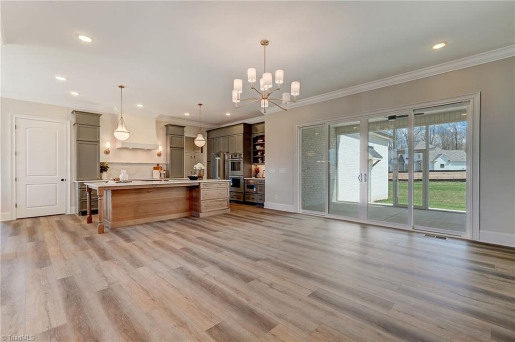 6806 Brennan Way Oak Ridge, NC 27310 - Photo 10 of 50 view from the other side of great room into kitchen (door on left is your walk in pantry)