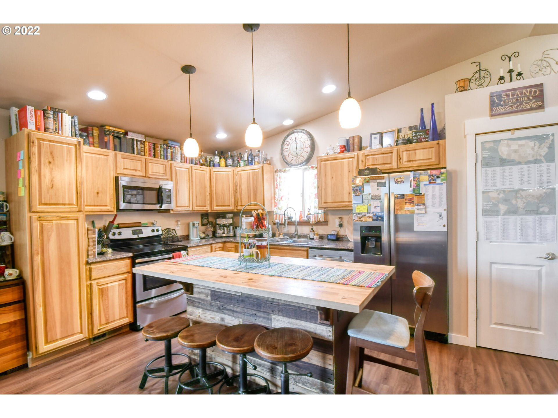 831 South Main Street Pendleton, OR 97801 - Photo 11 of 26 a kitchen with stainless steel appliances kitchen island granite countertop a table chairs and a refrigerator