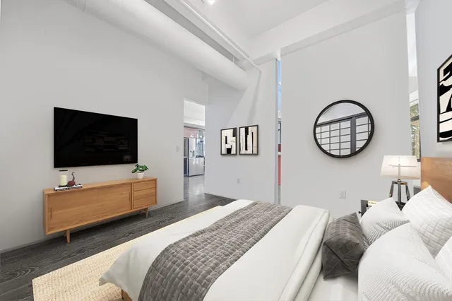 a bedroom with a bed and a flat screen tv