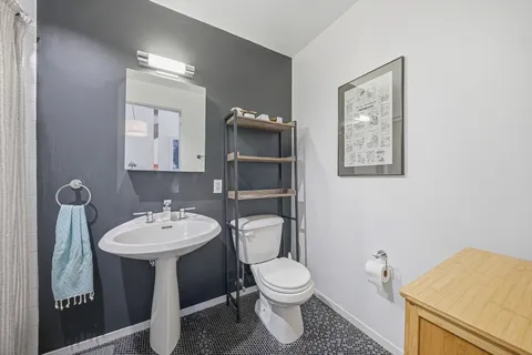 a bathroom with a toilet sink and mirror