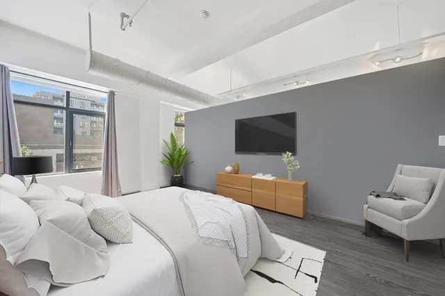 a bedroom with a bed and large window