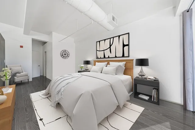 a bedroom with a bed and wooden floor