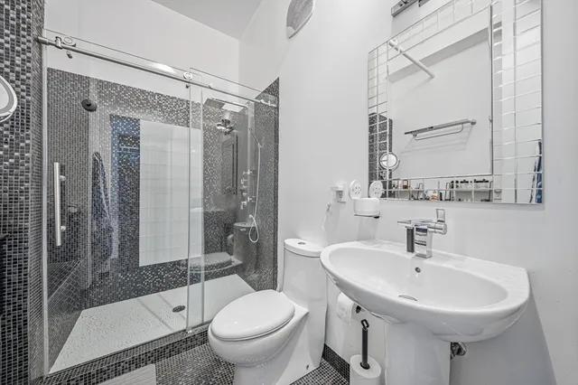 a bathroom with a sink toilet and shower