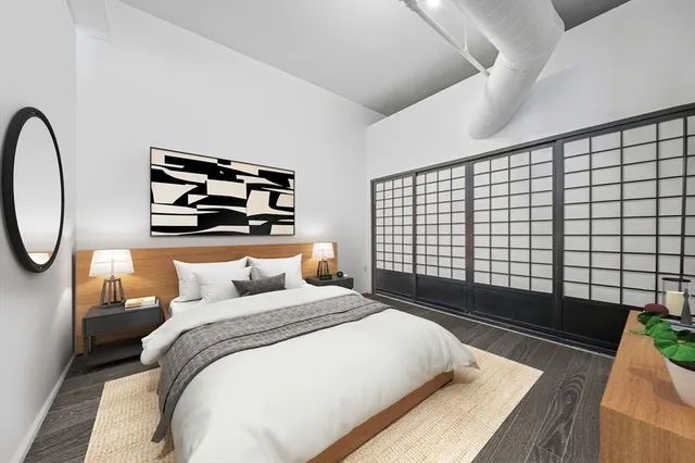 a bedroom with bed and a painting on the wall