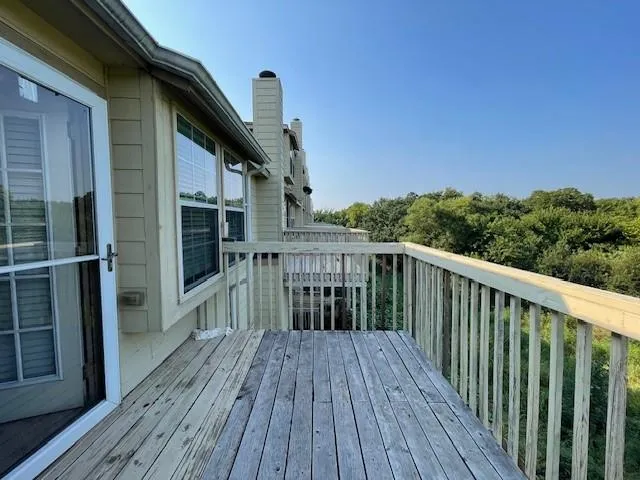 a balcony with wooden floor and city view