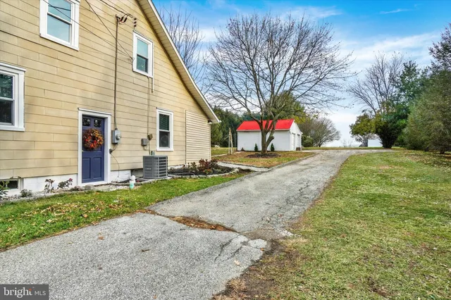 a street sign on a sidewalk next to a yard