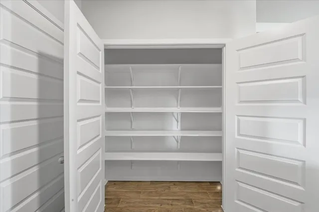 a view of walk in closet with empty racks