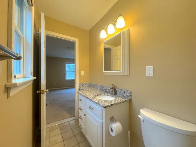 a bathroom with a granite countertop sink and a mirror