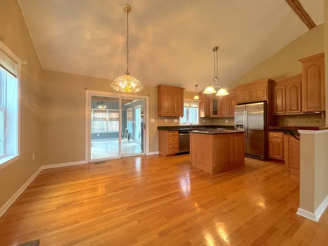 a view of a kitchen with granite countertop stainless steel appliances and a chandelier