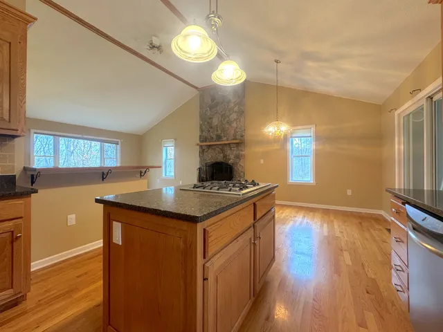 a kitchen with granite countertop a sink cabinets and wooden floor