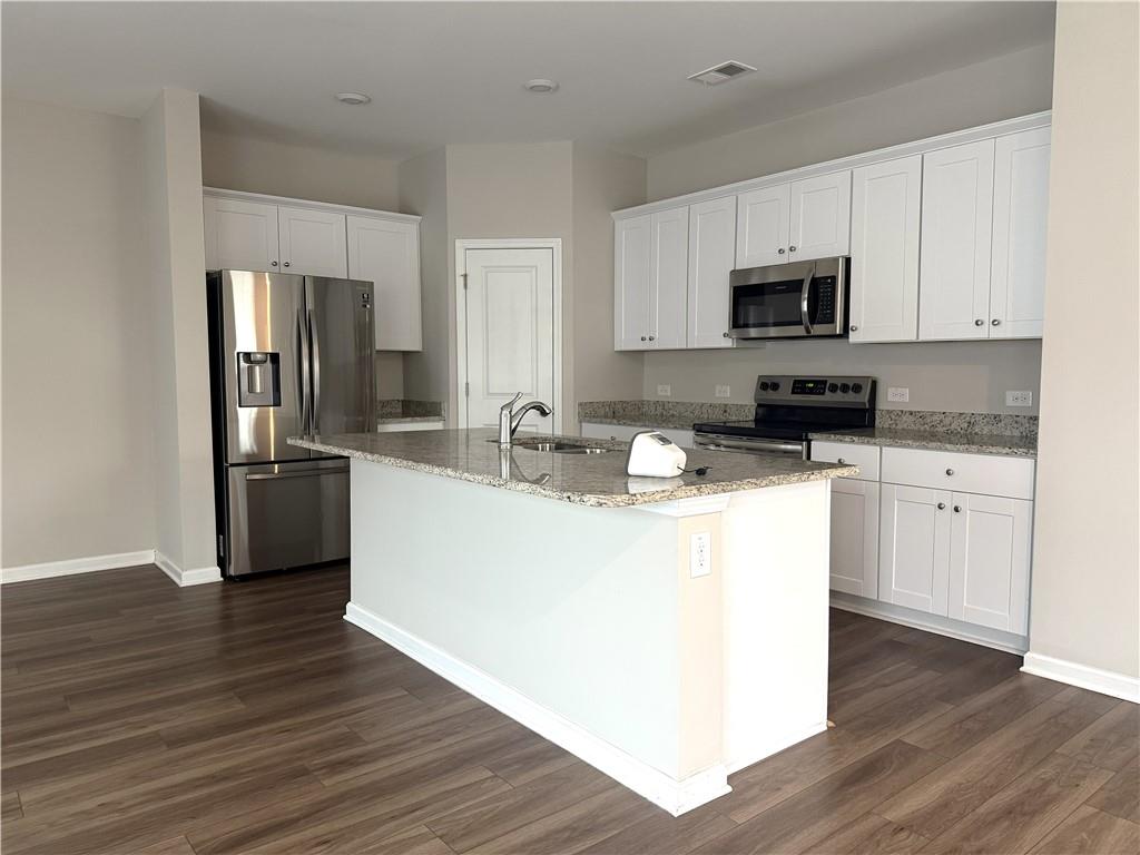 108 Seed Lane Pendergrass, GA 30567 - Photo 4 of 15 a kitchen with stainless steel appliances a sink a stove top oven a refrigerator a white counter top space and cabinets
