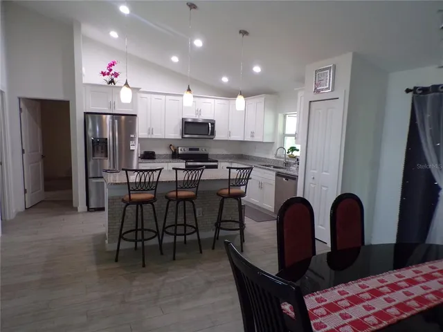 a kitchen with stainless steel appliances kitchen island granite countertop a refrigerator and microwave