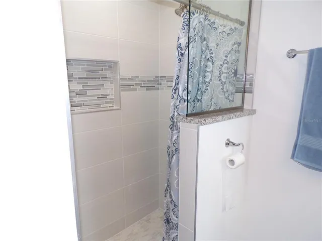 a bathroom with a granite countertop sink a toilet and mirror