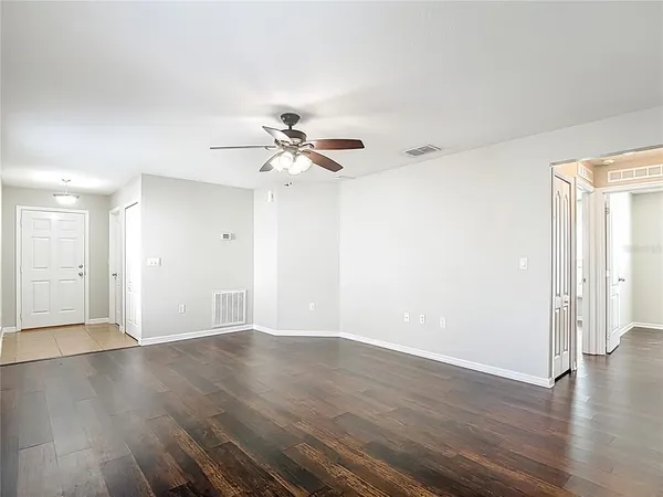 a view of an empty room with wooden floor