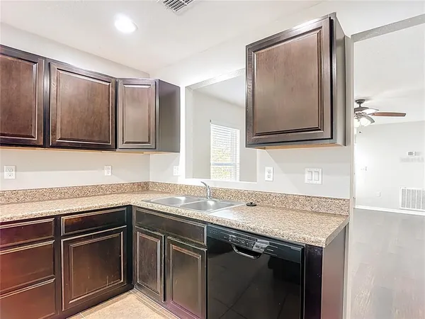 a kitchen with granite countertop stainless steel appliances and wooden cabinets