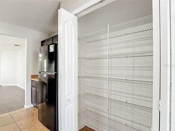 an empty room with wooden floor closet and windows