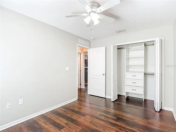 an empty room with a window and a ceiling fan