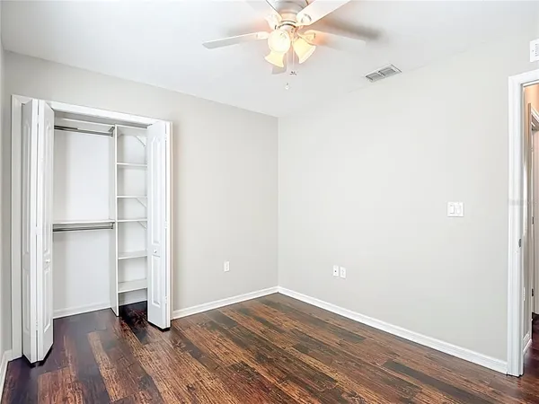 a view of an empty room with window and wooden floor