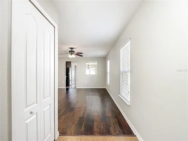 a view of a hallway with wooden floor and staircase