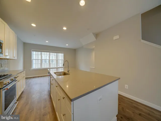 a kitchen with granite countertop a sink a stove and cabinets