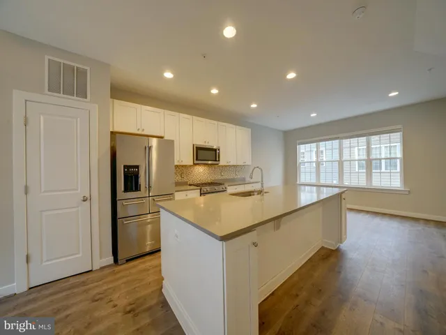 a kitchen with a sink and wooden floor