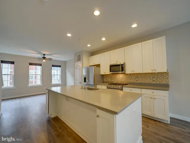 a kitchen with stainless steel appliances a stove a sink and a microwave