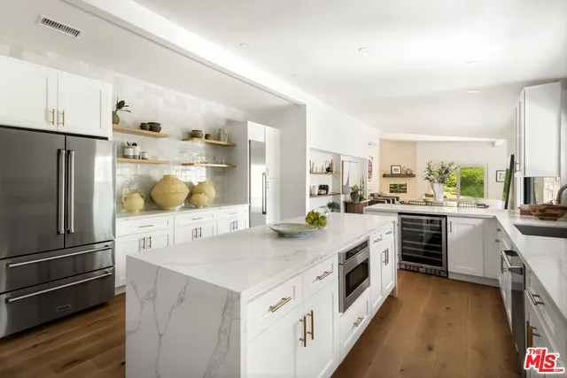 a kitchen with stainless steel appliances a stove a sink and a refrigerator