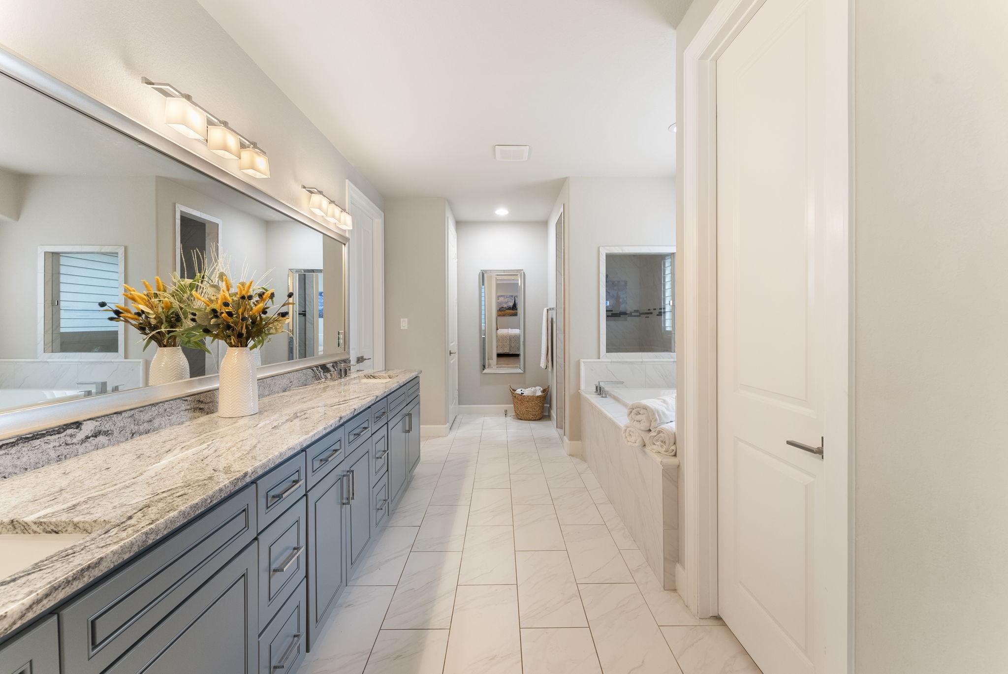 25607 Muirfield Bend Court Spring, TX 77389 - Photo 16 of 30 Spa-inspired primary bath featuring an extended dual-sink vanity with abundant storage, premium stone countertops, and a bright, sophisticated design that blends luxury with everyday functionality.