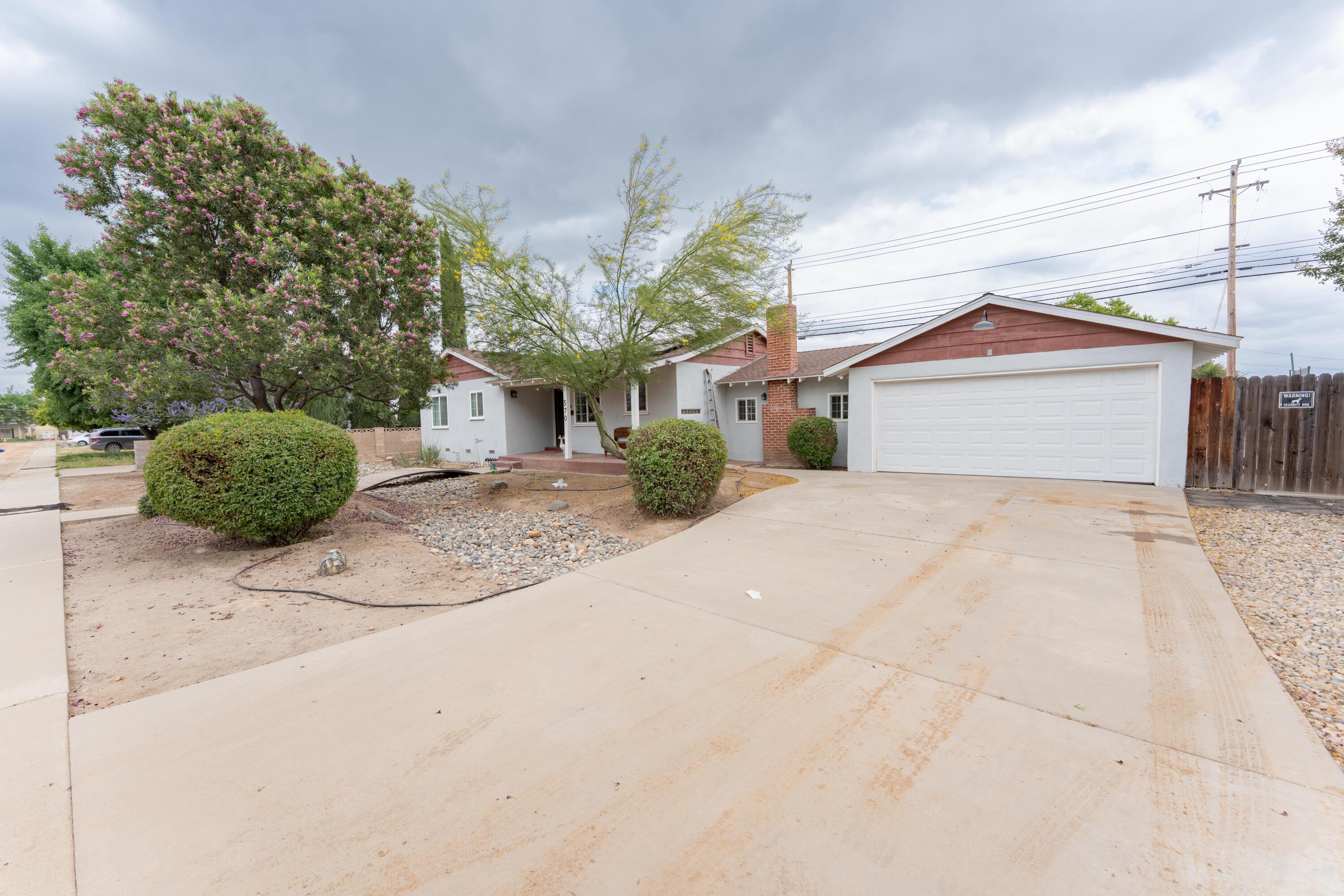 570 North Birch Avenue Reedley, CA 93654 - Photo 7 of 52 a front view of a house with a yard and garage