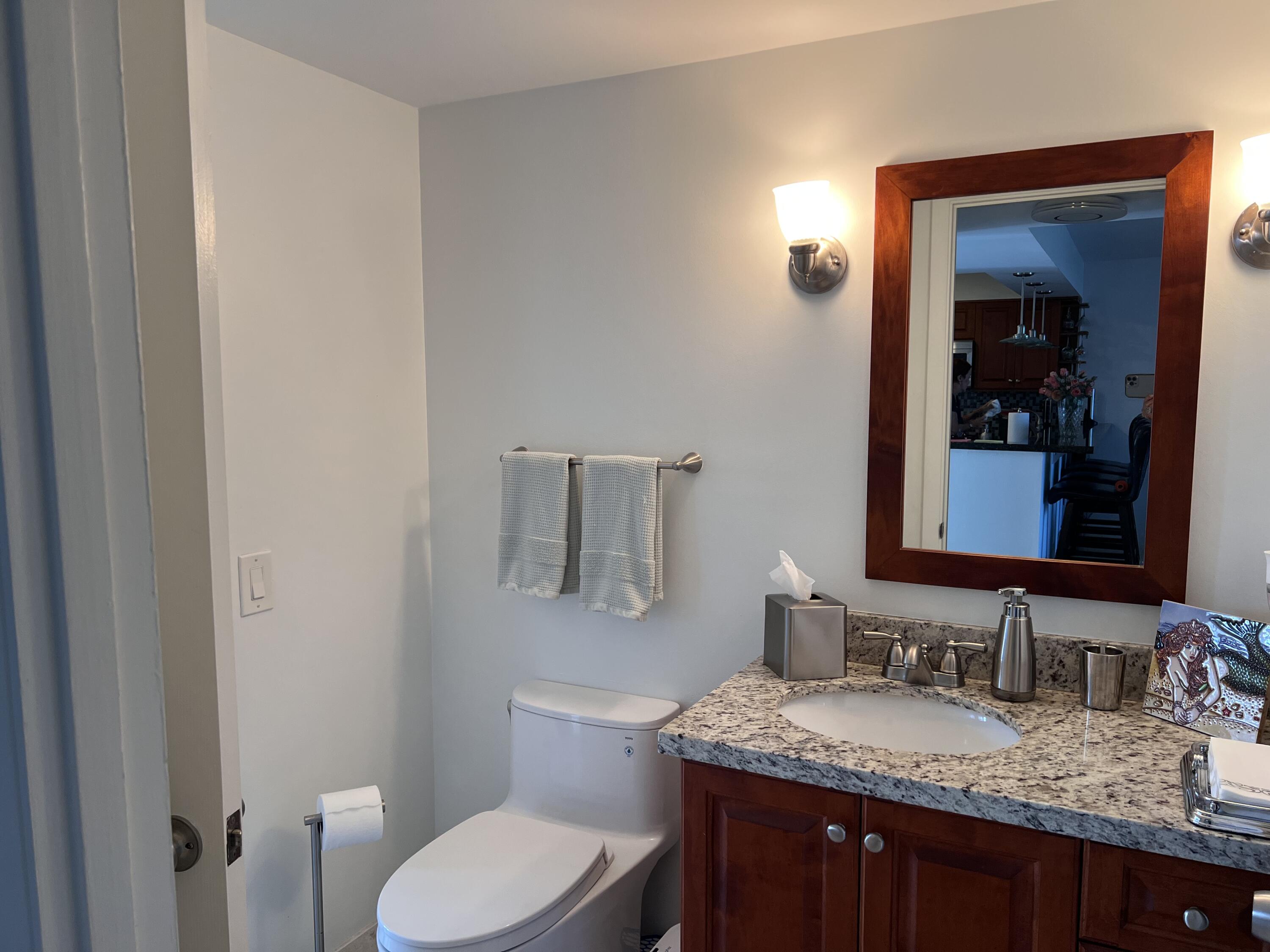 1629 Riverview Road, Unit 716 Deerfield Beach, FL 33441 - Photo 27 of 44 a bathroom with a granite countertop sink toilet and mirror