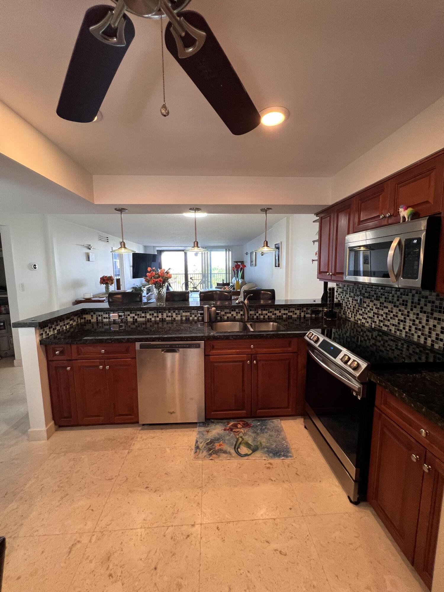 1629 Riverview Road, Unit 716 Deerfield Beach, FL 33441 - Photo 10 of 44 a large kitchen with a stove a sink a microwave and cabinets