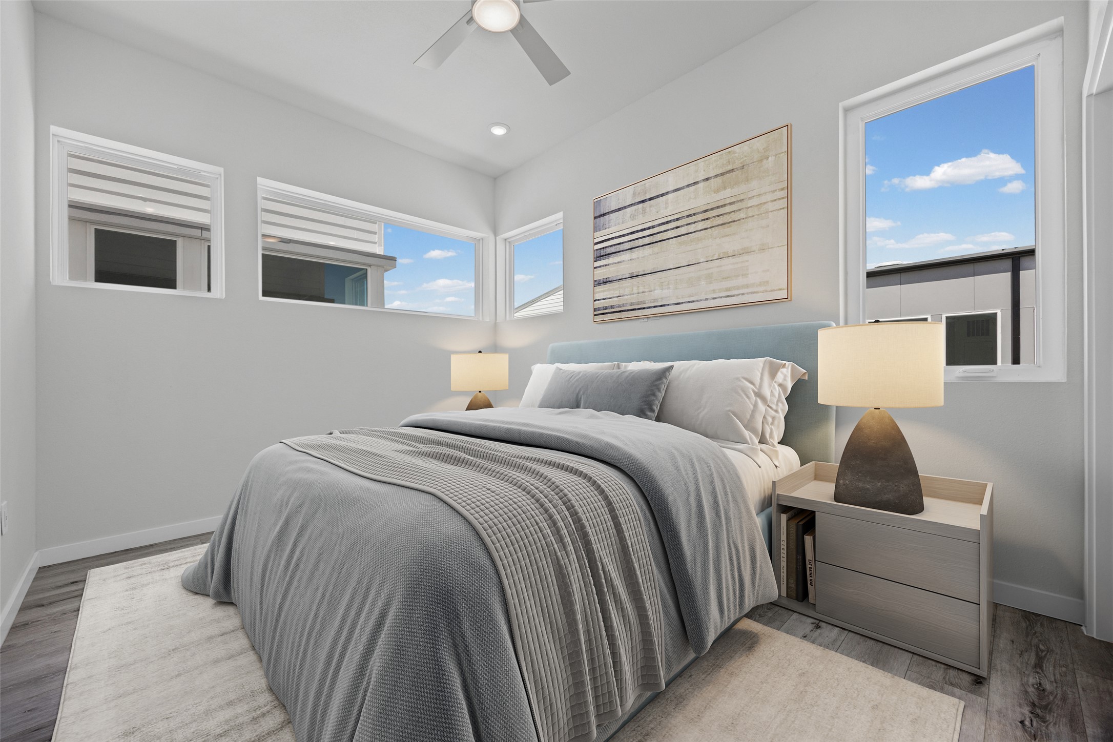 2000 Riverside Farms Road, Unit 5102 Austin, TX 78741 - Photo 20 of 25 Natural light streams into this serene primary bedroom, highlighting the contemporary ceiling fan and sleek flooring.