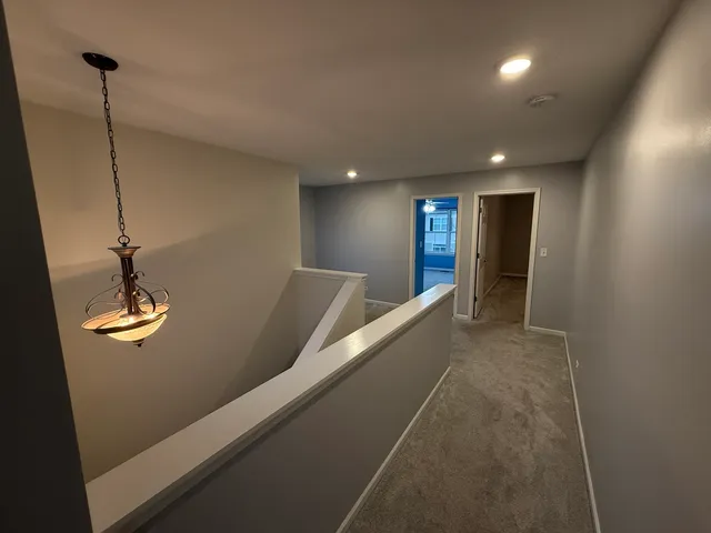 a view of an empty room with a chandelier fan