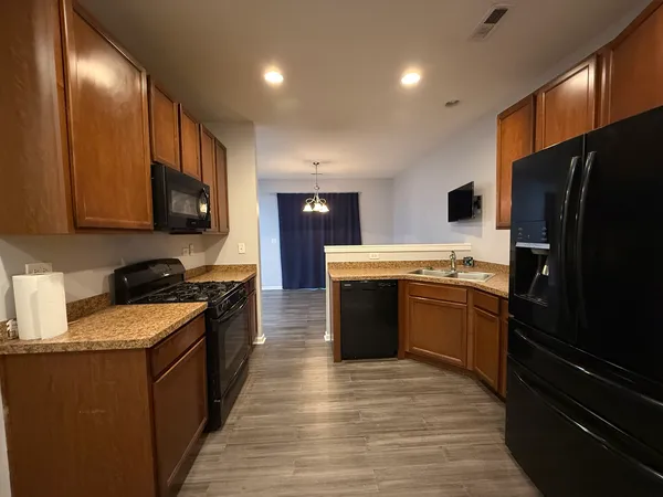 a large kitchen with stainless steel appliances granite countertop a stove refrigerator sink and cabinets