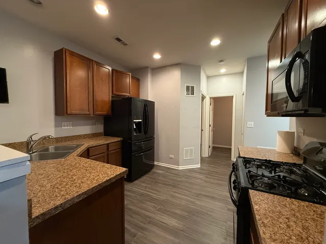 a kitchen with granite countertop stainless steel appliances and wooden cabinets