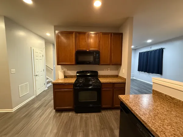 a kitchen with stainless steel appliances granite countertop a stove a sink and a microwave