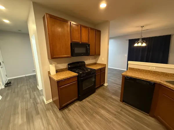 a kitchen with granite countertop a stove and a wooden floor