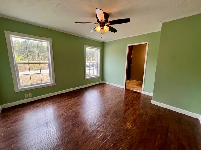 a view of a livingroom with wooden floor and a ceiling fan
