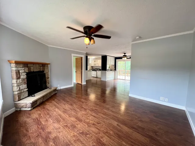 a view of empty room with wooden floor and fireplace