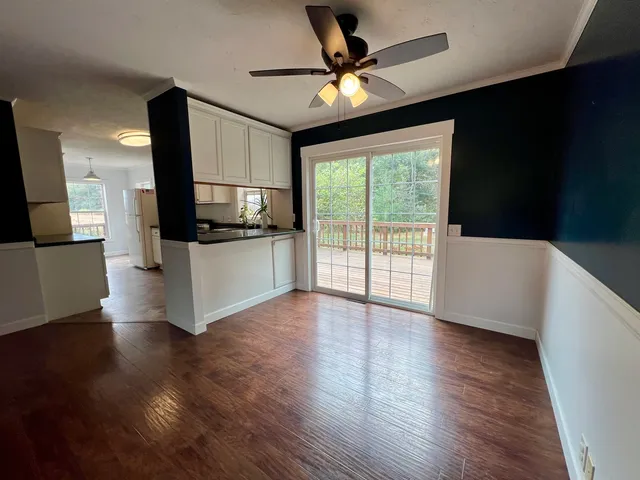 a view of a livingroom with furniture wooden floor a ceiling fan and a window