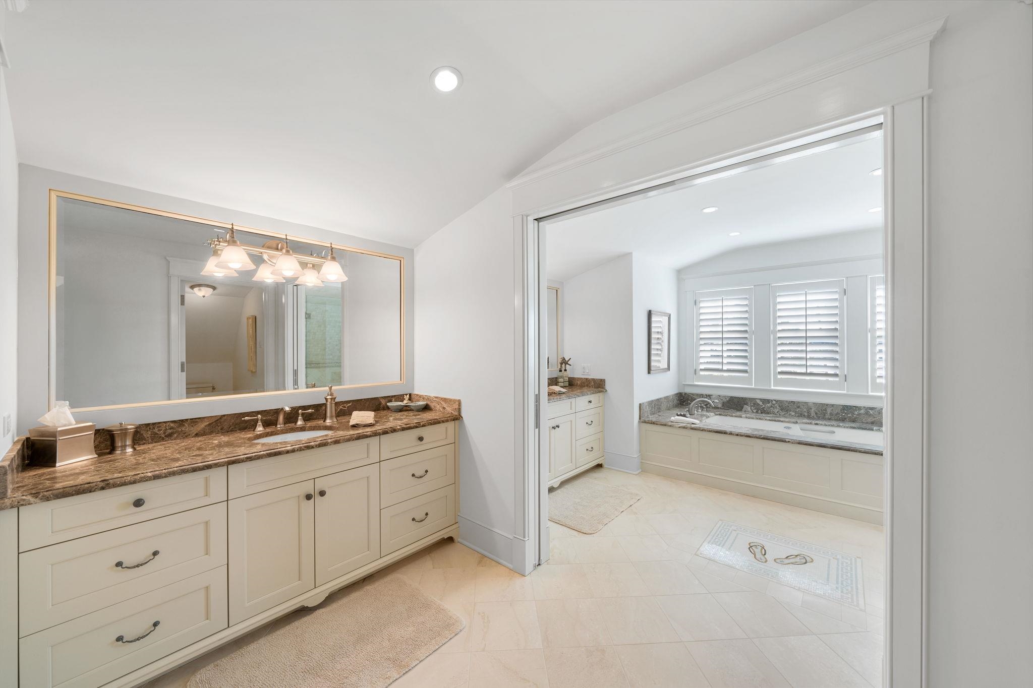501 42nd Street Avalon, NJ 08202 - Photo 27 of 50 a bathroom with a granite countertop sink mirror and bathtub