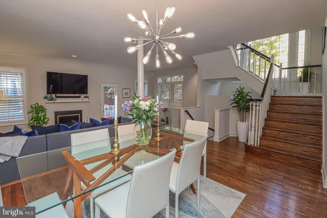 a dining room with furniture potted plants and wooden floor
