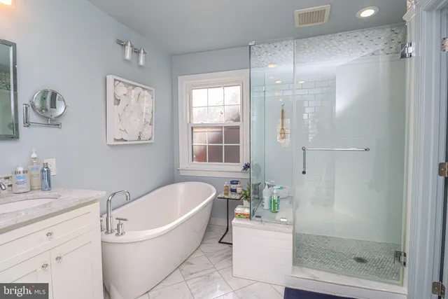 a bathroom with a bathtub shower sink and mirror