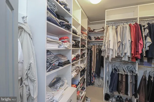 a view of walk in closet with clothes